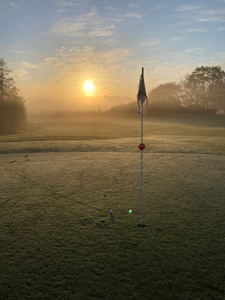 Golffahne mit aufgehender Sonne